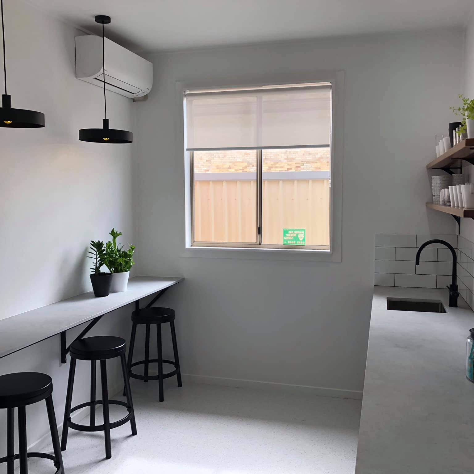 A grey kitchen with a breakfast bar and stools